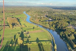 Panoramisch uitzicht over de rivier en velden tijdens een ballonvlucht in Oost-Vlaanderen