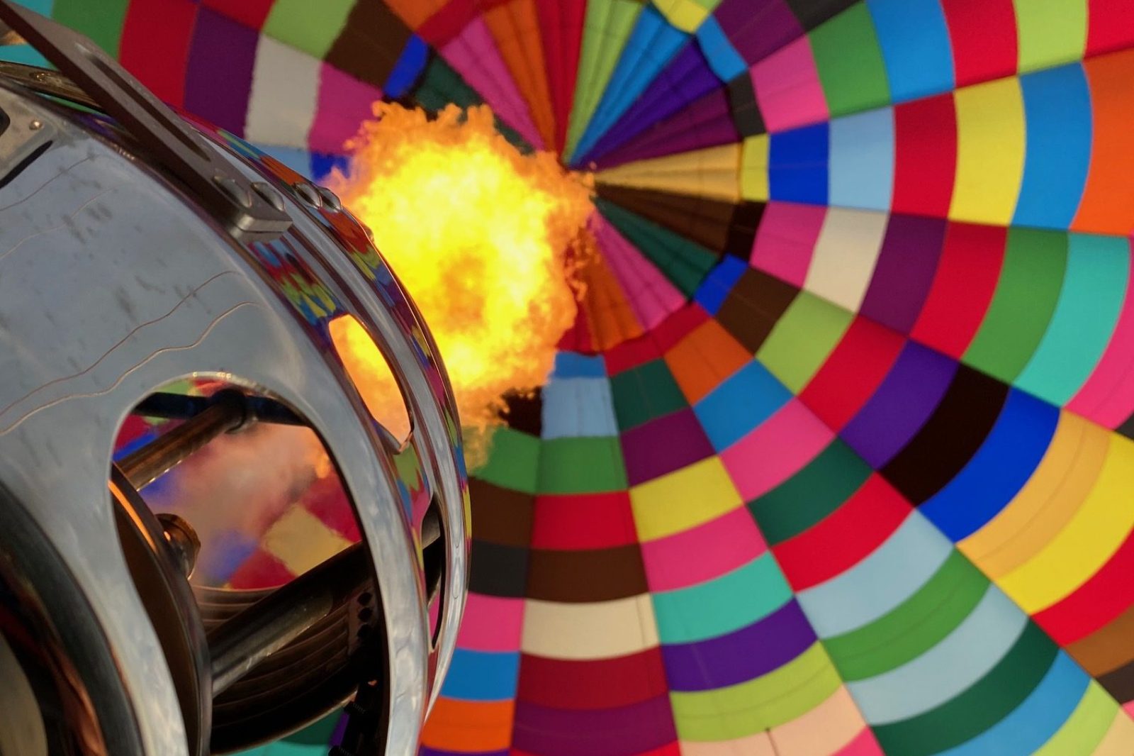 Close-up van de brander die een kleurrijke luchtballon vult voor de start van de vlucht