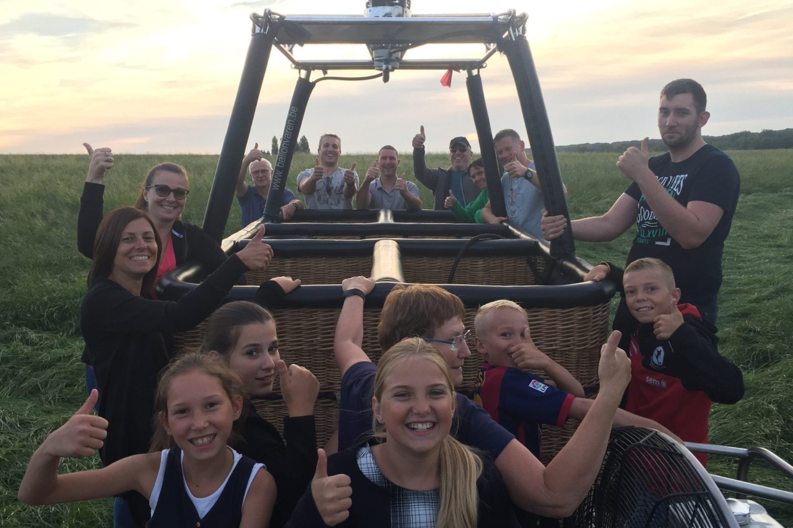 Blije groep passagiers klaar voor vertrek tijdens een ballonvaart in Lochristi