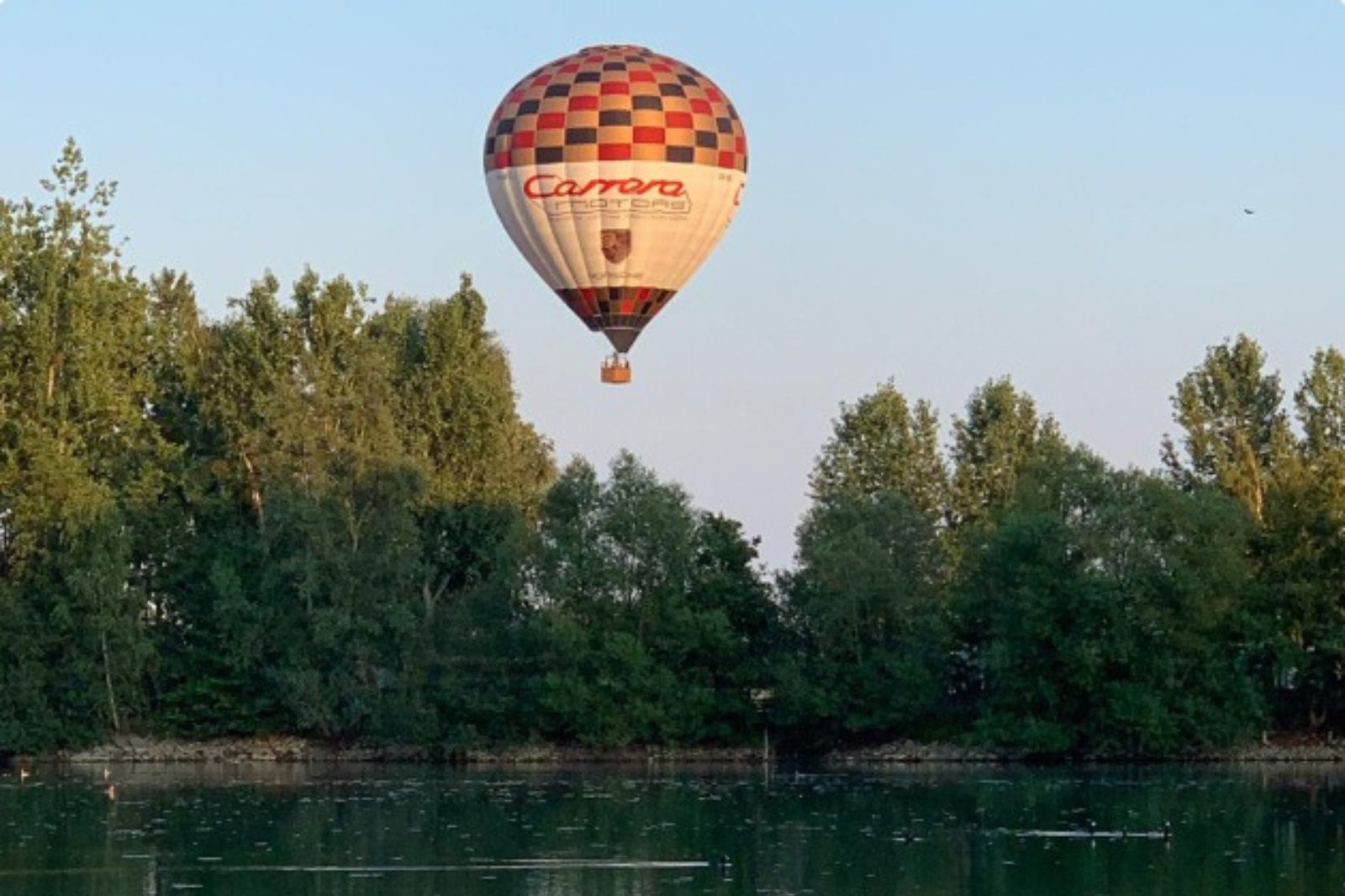 Luchtballon weerspiegelt in het water tijdens een rustige avondvlucht in Oudenaarde