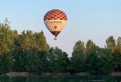 Ballonvaart over natuur en water in Oost-Vlaanderen met luchtballon boven groene omgeving
