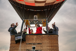 Ballonvaart met team in mand tijdens teambuilding, collega’s genieten van het uitzicht in de lucht