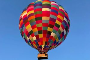 Kleurrijke luchtballon in de lucht als unieke ervaring voor communie of lentefeest