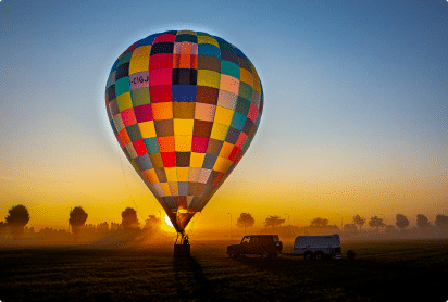 Kleurrijke luchtballon tijdens zonsondergang als romantische setting voor een huwelijksaanzoek in de lucht.