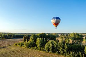 Ballonvaart als vaderdagcadeau boven rustig landschap met luchtballon in blauwe lucht