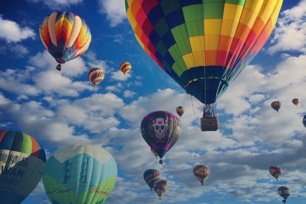 Meerdere kleurrijke luchtballonnen in de lucht als ervaring voor vaderdagcadeau