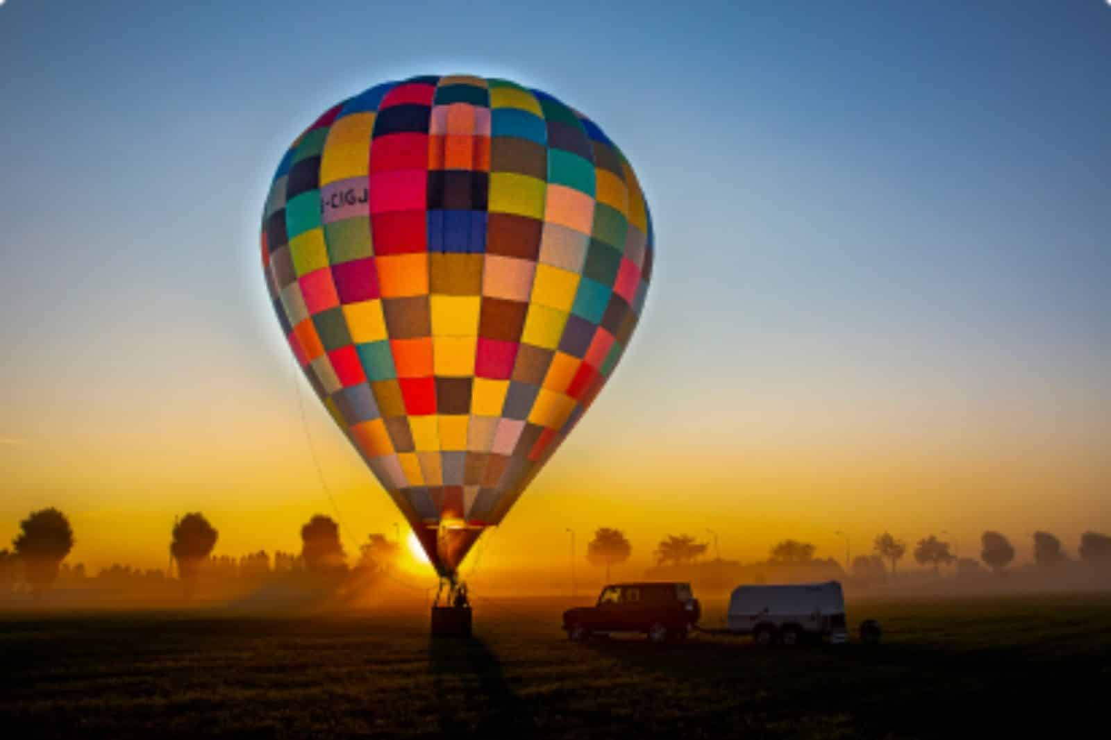Kleurrijke luchtballon klaar om op te stijgen bij zonsopgang tijdens een ballonvaart voor moederdag